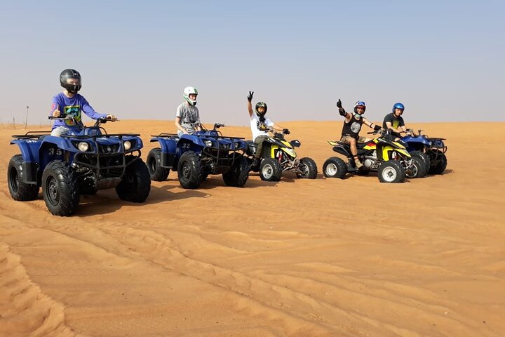 Experience the excitement of dune exploration as you navigate the stunning Red Dunes Desert on your quad bike creating unforgettable memories with friends and family in Dubai's majestic landscape.